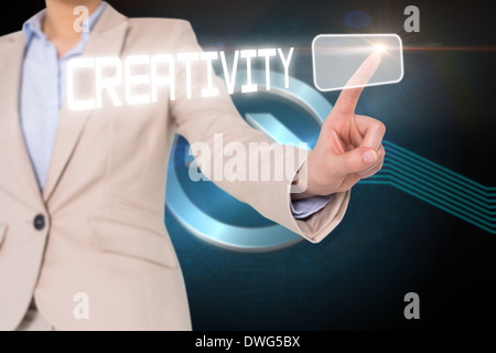 Businesswomans finger touching creativity button Stock Photo