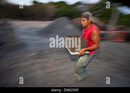 Penonome, Cocle province, Republic of Panama. 7th March, 2014. Raul Antonio Alueo, 29, carries newly pressed concrete blocks at the construction material plant Industrias Gordon S.A in Penonome, Cocle province, Republic of Panama, on Friday March 7, 2014. Stock Photo