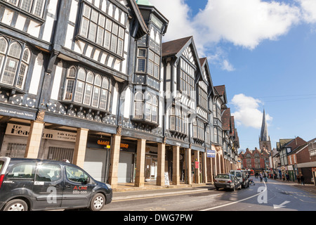 Tudor Revival style (aka Mock Tudor) buildings on Knifesmithgate, Chesterfield, England, UK. St Marys church with the crooked spire is in the distance Stock Photo