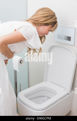Woman with stomach sickness about to vomit into toilet Stock Photo