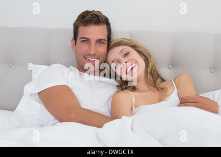 Relaxed young couple sitting in bed Stock Photo