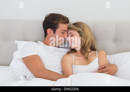 Relaxed young couple sitting in bed Stock Photo