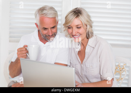 Smiling mature couple using laptop Stock Photo
