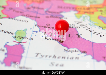 Round red thumb tack pinched through city of Rome on Italy map. Part of collection covering all major capitals of Europe. Stock Photo