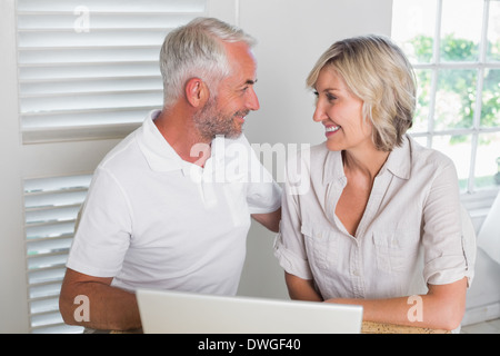 Smiling mature couple using laptop Stock Photo