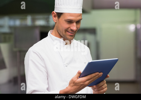 Happy chef using tablet pc Stock Photo
