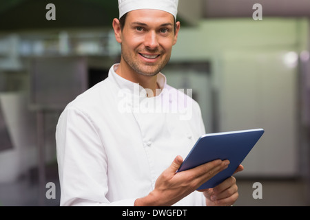 Happy chef using tablet pc Stock Photo