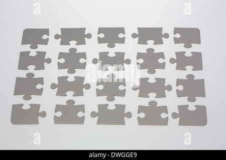 20 jigsaw puzzle pieces placed on illuminated white background. Stock Photo