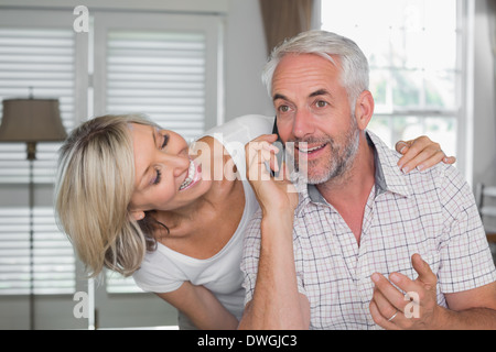 Woman with mature man while he's using mobile phone Stock Photo