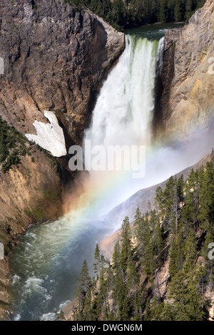 A rainbow forms near the base of Lower Falls along Grand Canyon of the Yellowstone River in Yellowstone National Park, Wyoming. Stock Photo