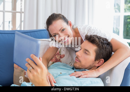 Loving couple reading book on couch Stock Photo