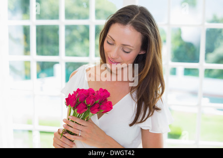 Thoughtful woman with flowers at home Stock Photo
