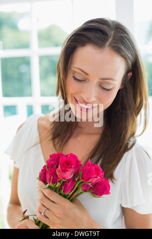 Thoughtful woman with flowers at home Stock Photo