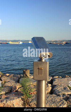 Metallic coin operated viewer for tourists to look at against coastal. Including clipping path Stock Photo