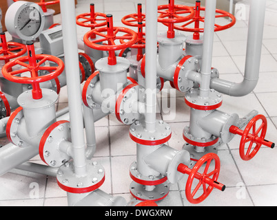 Group of red industrial valves on gray pipelines Stock Photo