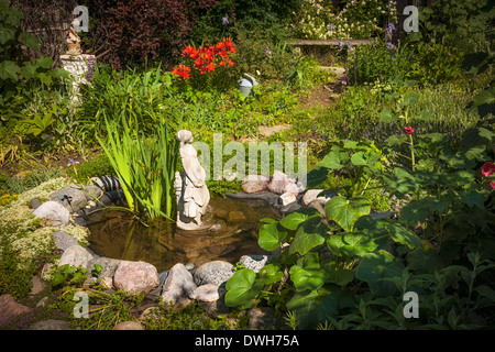 Statue in small pond of natural summer garden Stock Photo