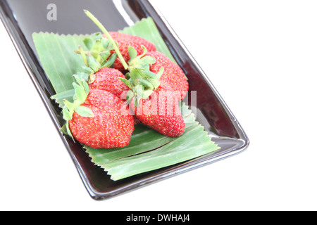 Four Strawberry in black dish on white background Stock Photo - Alamy