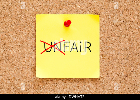 Turning the word Unfair into Fair with red marker on yellow sticky note pinned with red push pin. Stock Photo