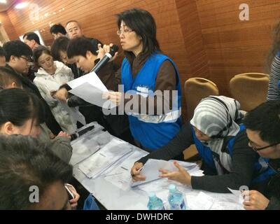 (140309) -- BEIJING, March 9, 2014 (Xinhua) -- A member of a special assistance team of Malaysian Airlines speaks to the relatives of those on board the missing flight during a follow-up meeting in Beijing, capital of China, March 9, 2014. The company will update relatives on the latest situation in every 15 minutes, said the airline's spokesman. The Malaysia Airlines Flight MH370, a Boeing B777-200, lost communication and radar signal on its flight from Malaysia's capital Kuala Lumpur to Beijing on early Saturday morning. On board were 227 passengers from 14 countries, including 154 Chinese, Stock Photo