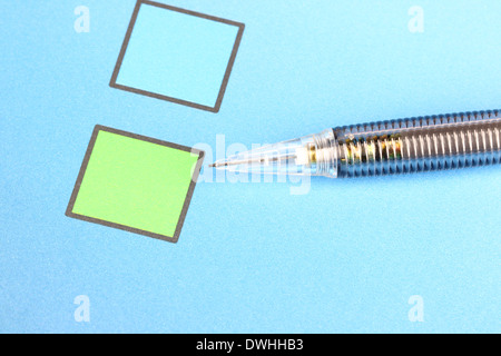 Closeup Mechanical pencil point to Green Checkbox on blue background. Stock Photo