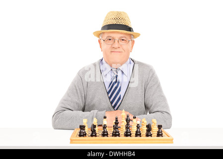 Male pensioner posing behind a chessboard Stock Photo