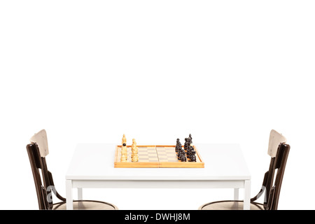 Studio shot of a table with chessboard on it and two wooden chairs Stock Photo