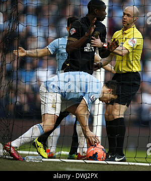 Manchester. 9th Mar, 2014. Samir Nasri (bottom) of Manchester City picks up the ball after scoring the team's only goal during FA Cup quarterfinal match between Manchester City and Wigan at Etihad Stadium in Manchester, Britain on March 9, 2014. Manchester City lost 1-2. © Wang Lili/Xinhua/Alamy Live News Stock Photo