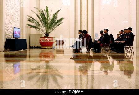 (140310) -- BEIJING, March  10, 2014 (Xinhua) -- Staff members watch live broadcast of the third plenary meeting of the second session of China's 12th National People's Congress (NPC) at the Great Hall of the People in Beijing, capital of China, March 10, 2014. (Xinhua/Zhang Yuwei) (zkr) Stock Photo