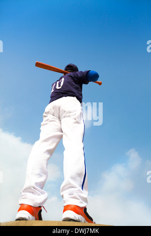 baseball player holding a bat  with blue sky outdoor Stock Photo
