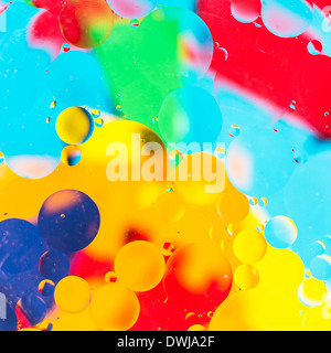 Oil drops in water on a coloured background Stock Photo