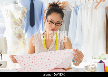 Concentrated female fashion designer at work Stock Photo