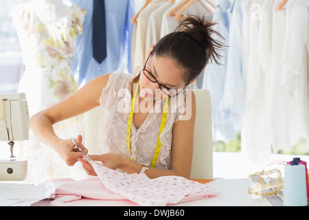Concentrated fashion designer working on fabrics Stock Photo