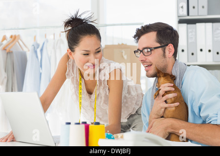 Fashion designers using laptop in studio Stock Photo
