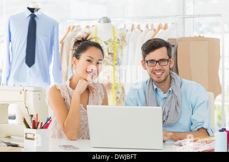 Fashion designers using laptop in studio Stock Photo