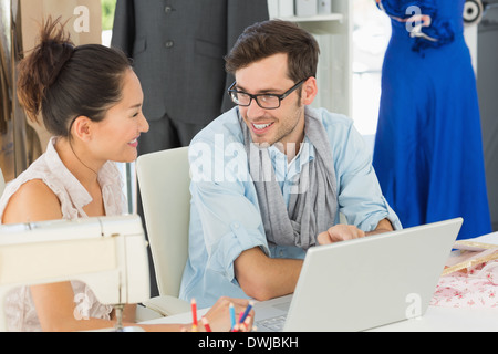 Fashion designers using laptop in studio Stock Photo