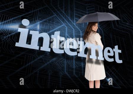 Businesswoman holding umbrella behind the word internet Stock Photo