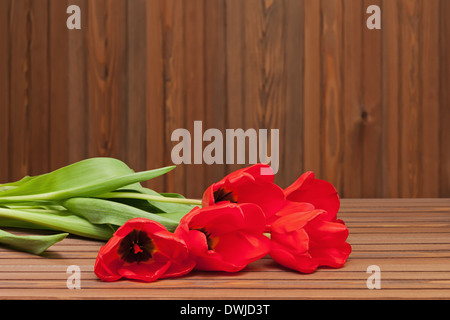 Red tulips on wooden background with space for text. Stock Photo