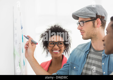 Artists in discussion in front of whiteboard Stock Photo