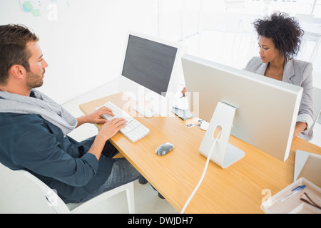 Young man and woman working on computers Stock Photo