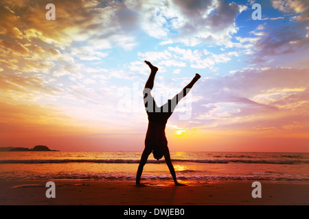 freedom and creativity, man jumping on the beach Stock Photo