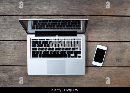 laptop and white smartphone on old wooden desk Stock Photo