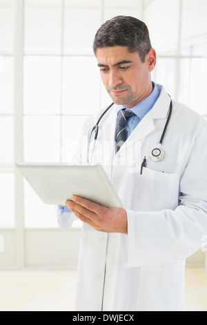 Serious male doctor using digital tablet Stock Photo
