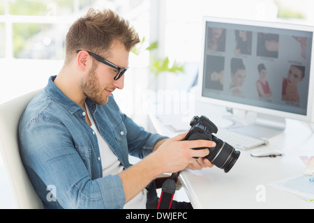 Handsome photographer looking at his camera Stock Photo