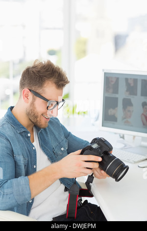 Handsome photographer holding his camera and smiling Stock Photo