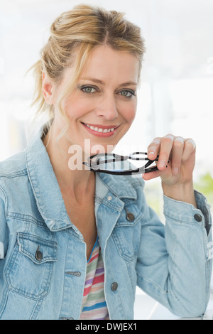 Blonde pretty designer looking at the camera with a smile Stock Photo