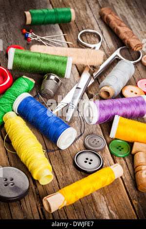 Scattered sewing spools and buttons, scissors and needles Stock Photo