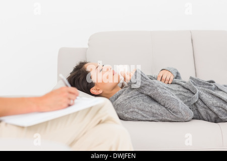 Therapist taking notes on her crying patient on the couch Stock Photo