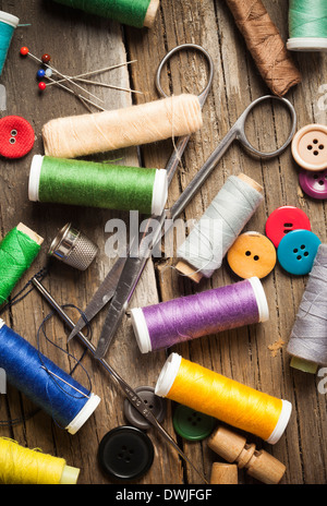 Scattered sewing spools and buttons, scissors and needles Stock Photo