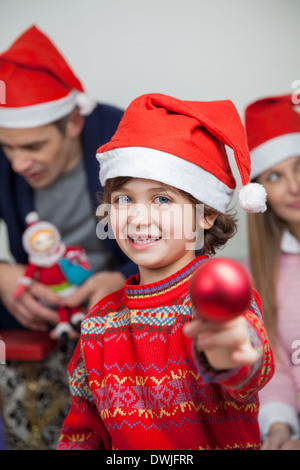 Boy Showing Christmas Decoration At Home