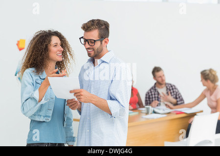 Happy designers looking at digital tablet together and chatting Stock Photo